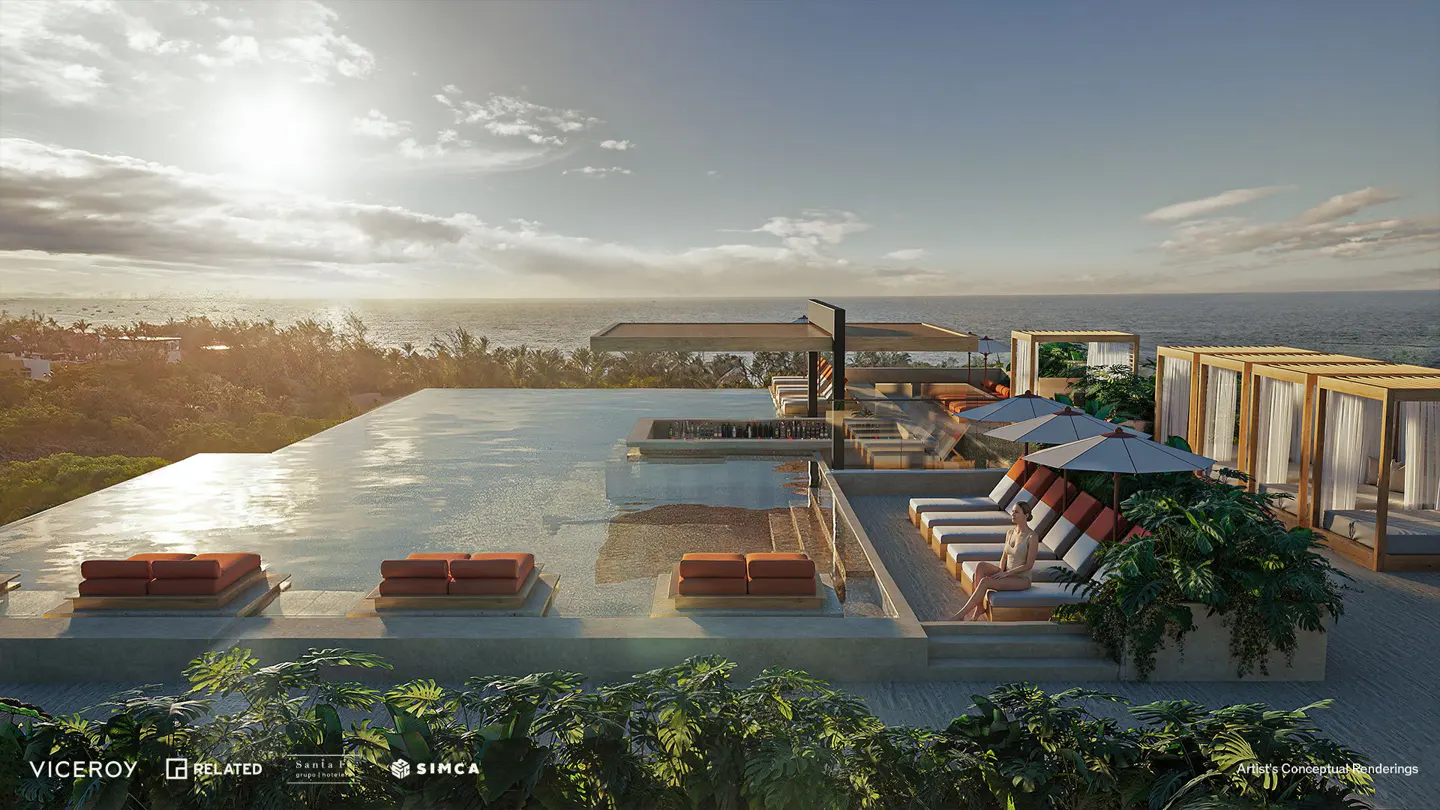 Rooftop pool with ocean view. Lounge chairs, cabanas, and lush greenery create a luxurious resort atmosphere.