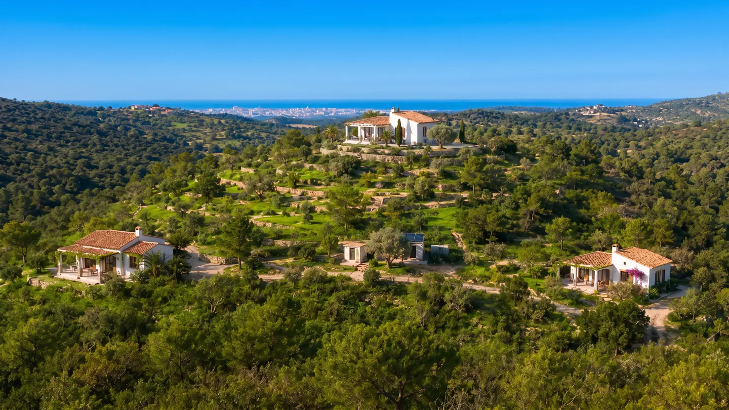 Scenic view of white houses with red tile roofs nestled on a green hillside under a clear blue sky.