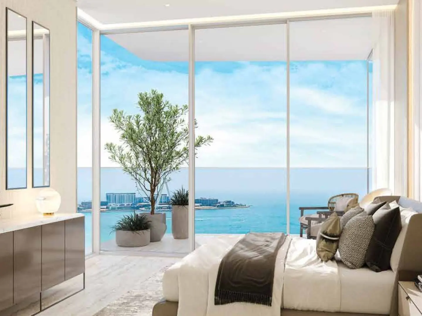 Bedroom with a large window view of the ocean. A bed with pillows and a throw blanket is in the foreground. A potted tree is on the balcony.