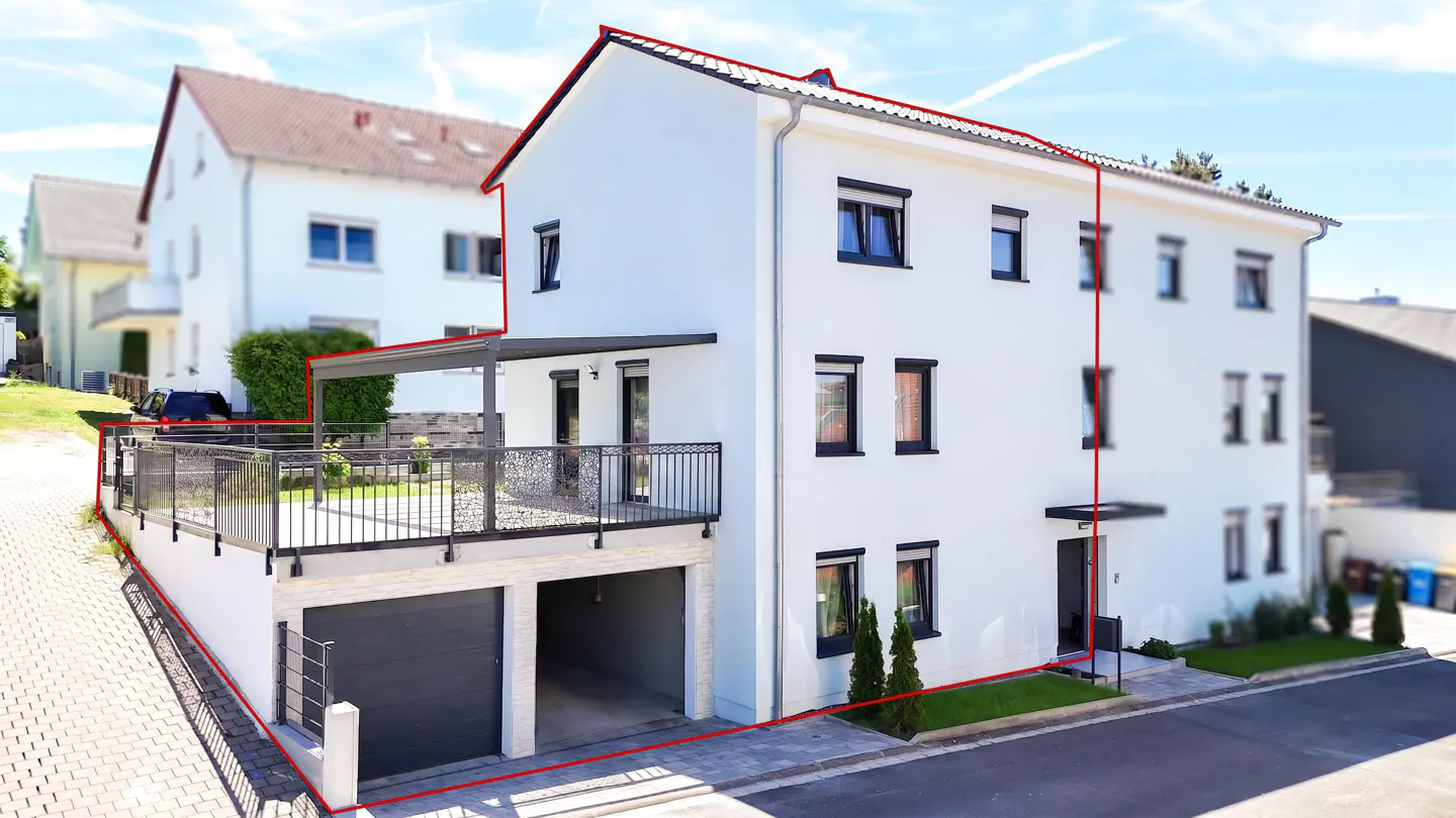 White multi-story house with a garage, balcony, and red outline highlighting the property boundaries on a sunny day.