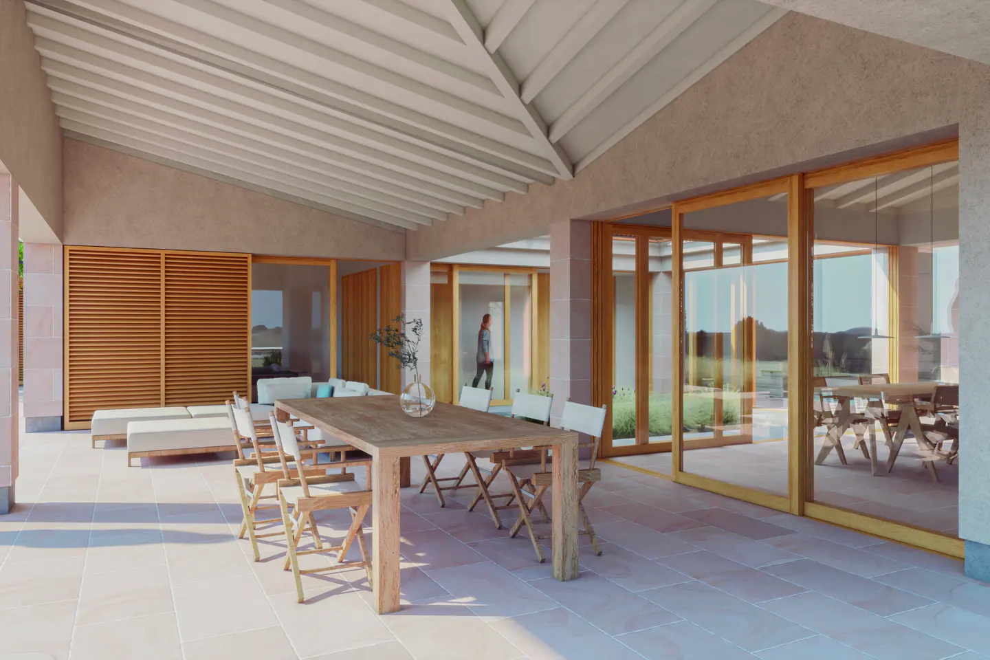 Covered patio with a long wooden table and chairs. Sliding glass doors lead to the interior. Loungers and a sofa are visible in the background.