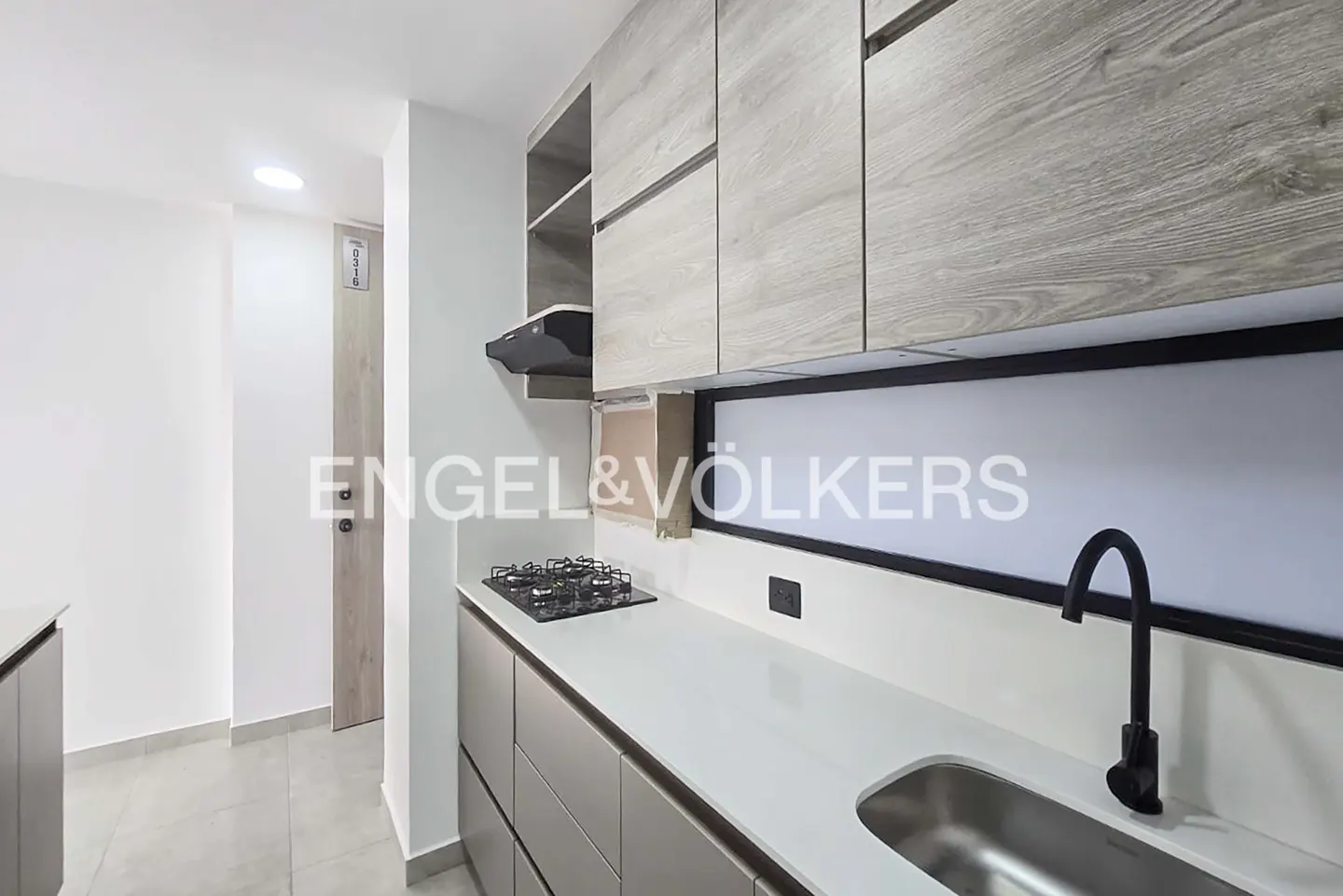 A modern kitchen with gray cabinets, white countertops, a black faucet, and a gas stove.