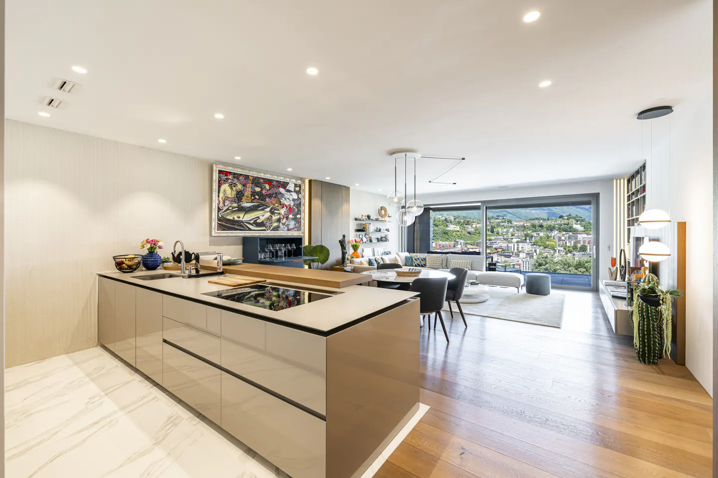 Open-concept living space with a kitchen island, dining table, and living room. A large window shows a city view.
