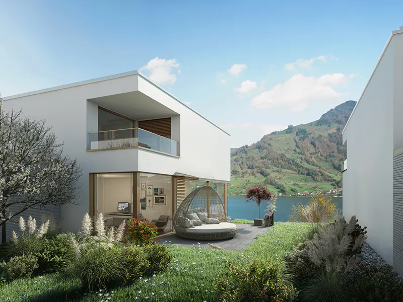 Modern white house with a balcony and a patio featuring a round daybed, overlooking a lake and mountains.