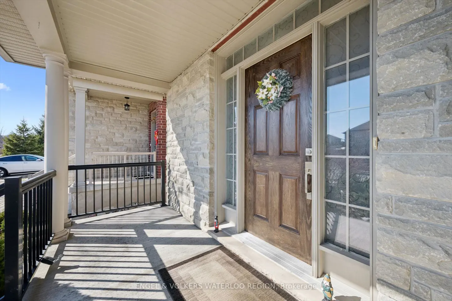 Front entrance of a stone house with a brown door and a floral wreath.