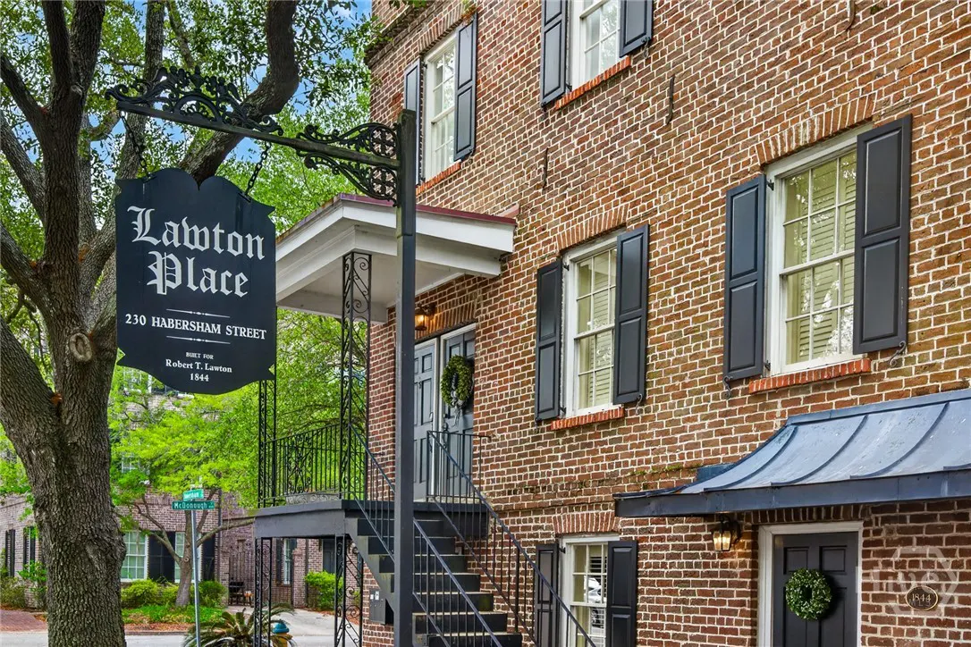 Exterior of Lawton Place, a brick building with black shutters and a sign reading "230 Habersham Street." A tree is on the left.