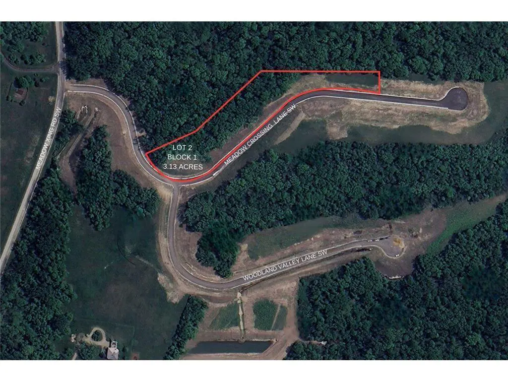 Aerial view of a 3.13-acre lot outlined in red, surrounded by dense green trees and winding roads. Text labels the lot and nearby streets.
