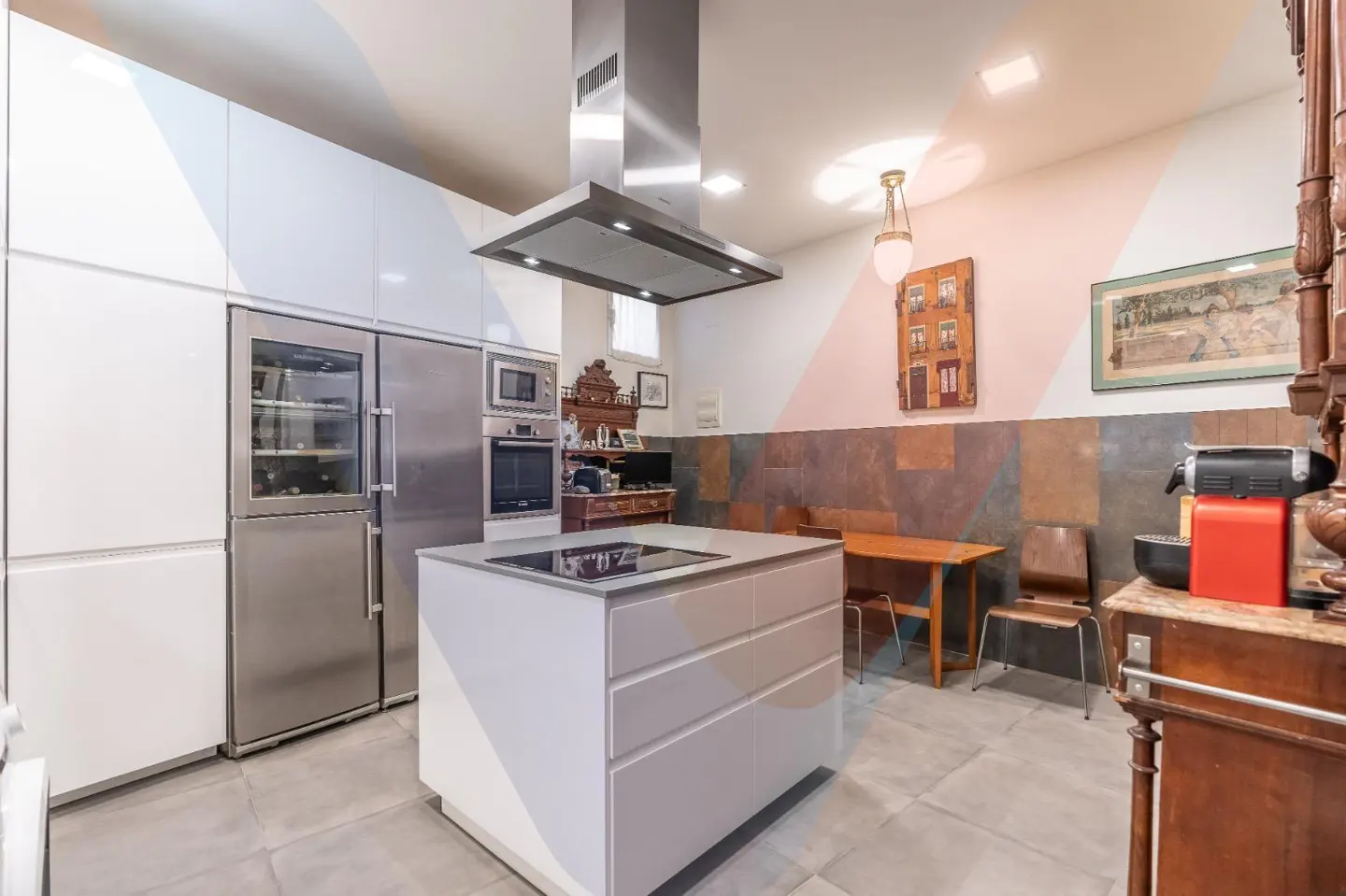 Modern kitchen with white cabinets, stainless steel appliances, and a white island. A dining table and chairs are in the background.
