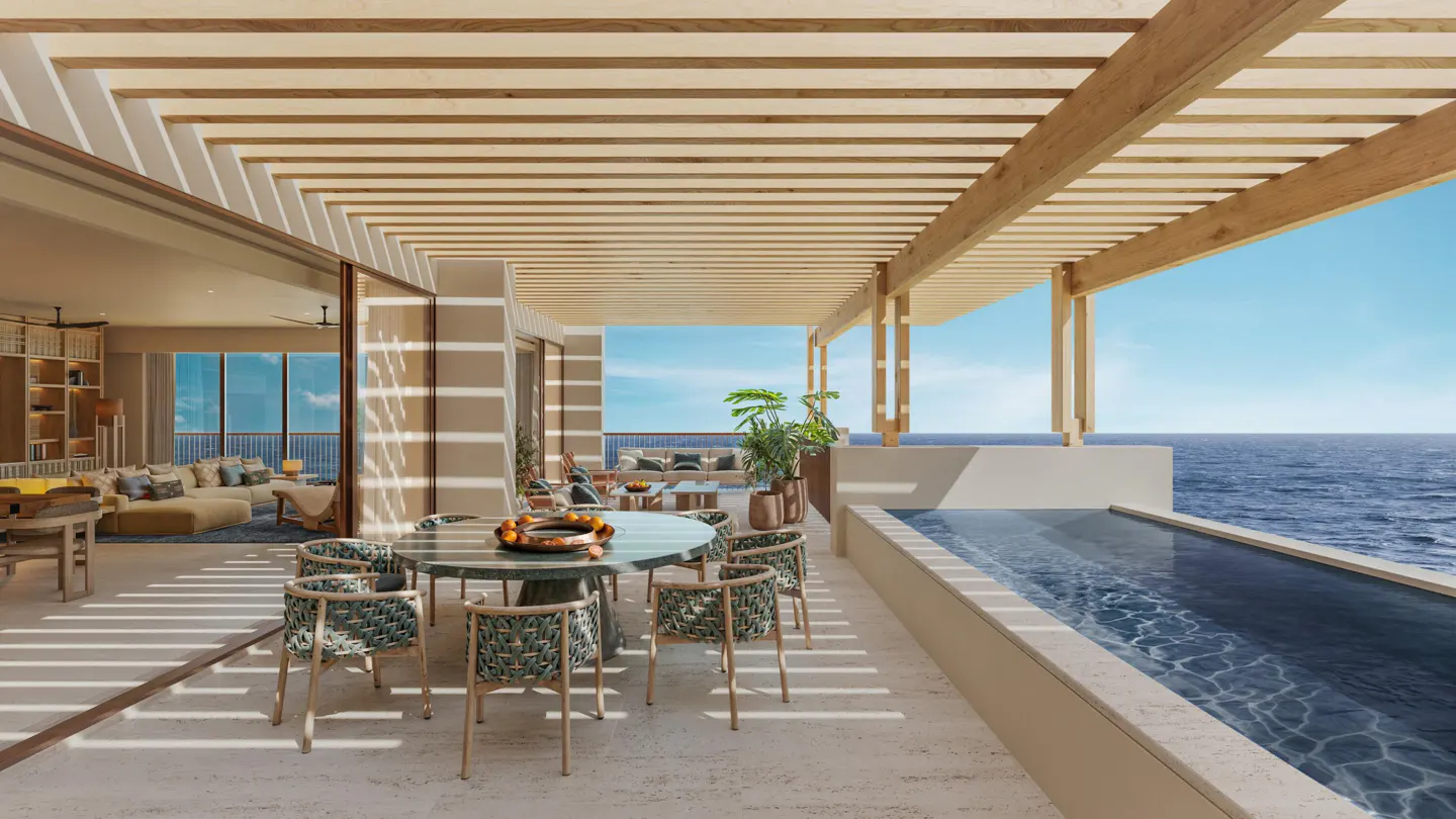 Luxury patio with a dining table, chairs, and a pool overlooking the ocean. A wooden pergola provides shade. Interior living space visible.