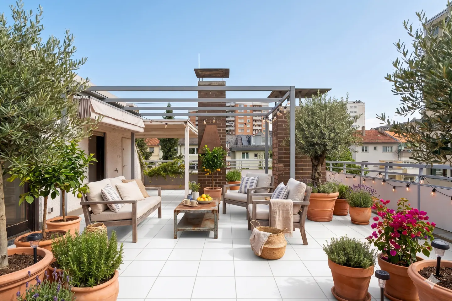 Rooftop patio with white tile, wood furniture, potted plants, and string lights. City buildings are visible in the background.
