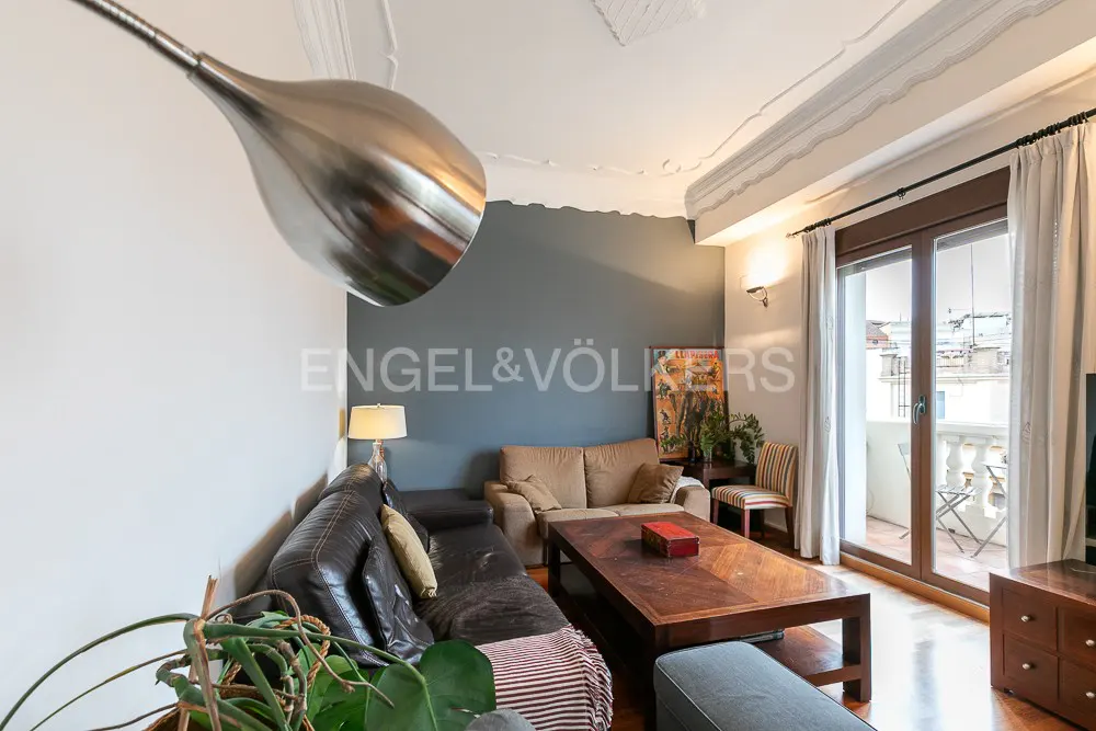 Living room with a brown leather sofa, beige sofa, wood coffee table, and balcony access. The walls are gray and white.
