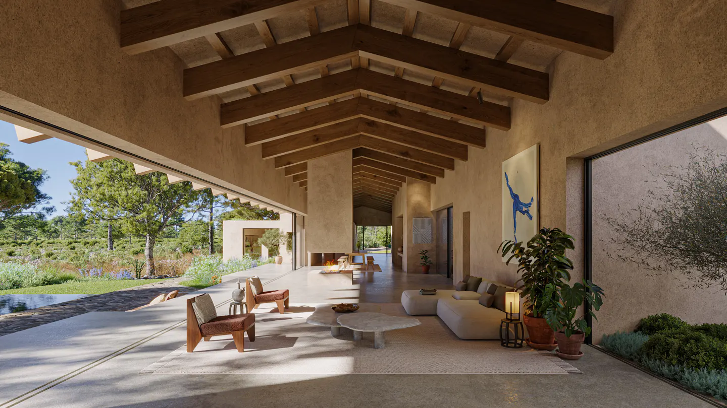 Open-concept living space with exposed wood beams, neutral tones, and large windows overlooking lush greenery. Modern furniture and artwork accent the space.