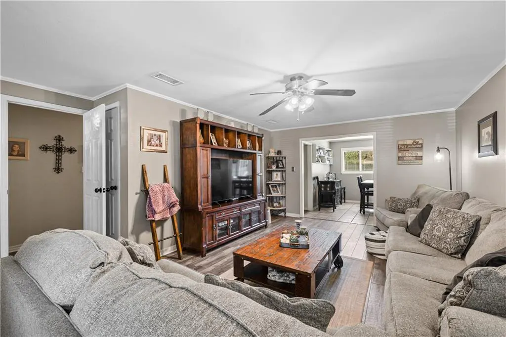 Cozy living room with grey sectional sofa, wooden coffee table, large media center, and view into a dining area.