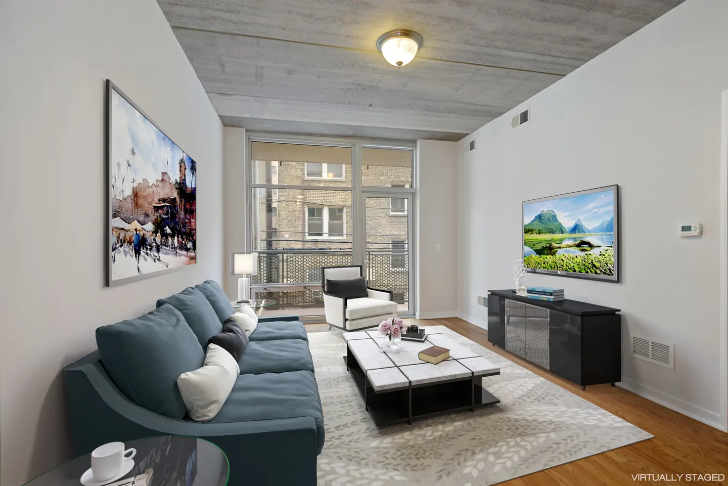 Living room with blue sofa, white armchair, marble coffee table, and large windows. Artwork and TV on walls.