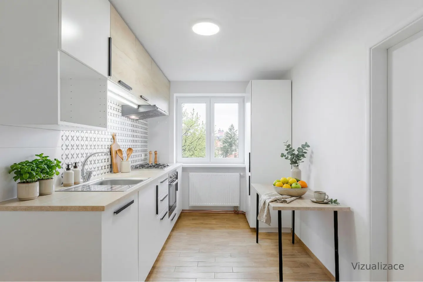 Bright, narrow kitchen with white cabinets, wood floors, and a window. A table with fruit and a vase sits against the right wall.
