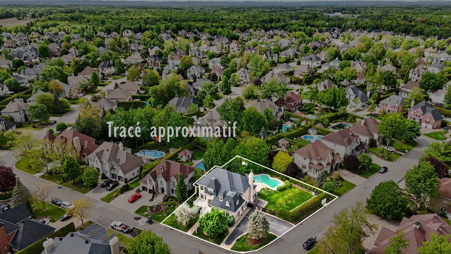 Aerial view of a large, beige house with a pool, surrounded by green trees and other houses in a suburban neighborhood.