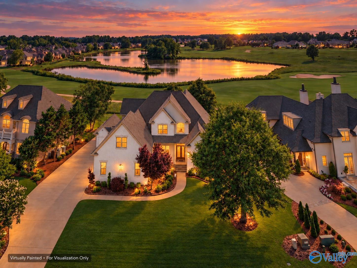 Aerial view of luxury homes at sunset, overlooking a golf course pond with warm golden light reflecting on the water. [AI-generated text]