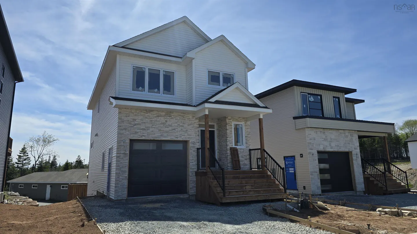 Two-story white house with a gray stone facade and a black garage door on a sunny day.