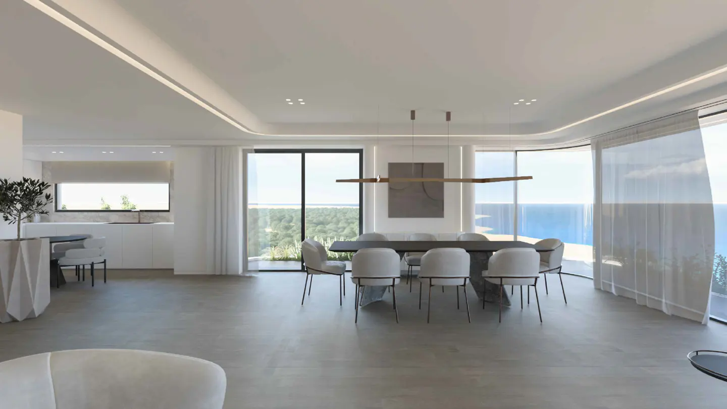 Bright, modern dining room with a long gray table and white chairs. Large windows offer ocean views. Minimalist decor, light wood floors.