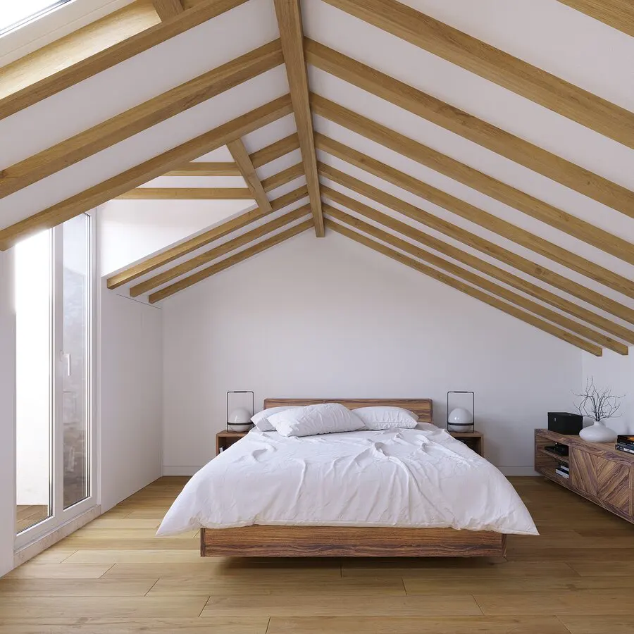 Modern attic bedroom with a wooden bed, white bedding, exposed ceiling beams, and a glass door leading to a balcony.