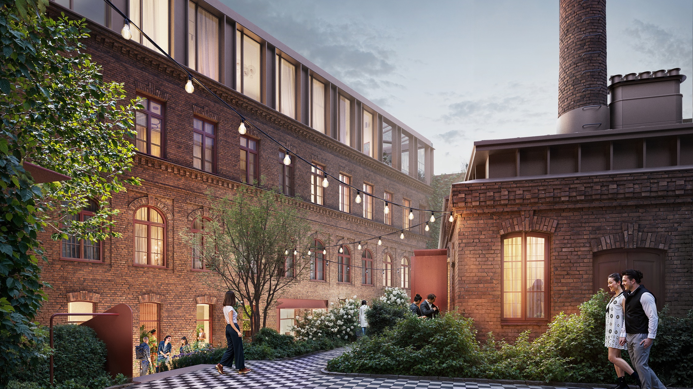 Exterior view of a brick building with a smokestack, string lights, and people walking on a black and white checkered path.