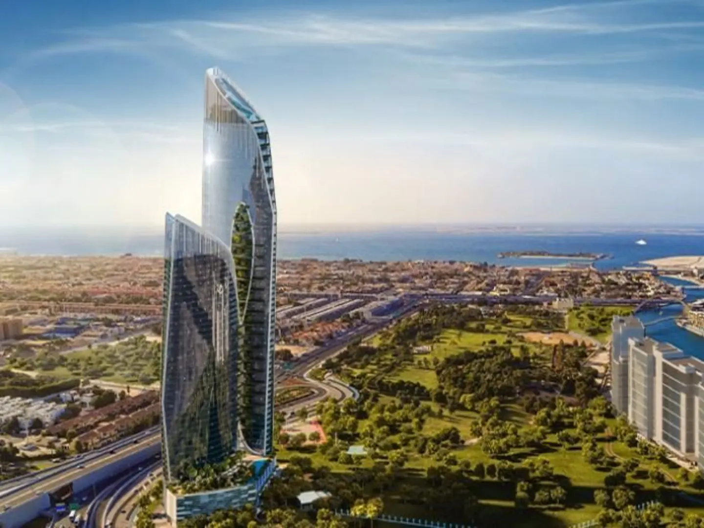 Modern glass skyscraper with curved design, set against a backdrop of city, green space, and ocean under a blue sky.