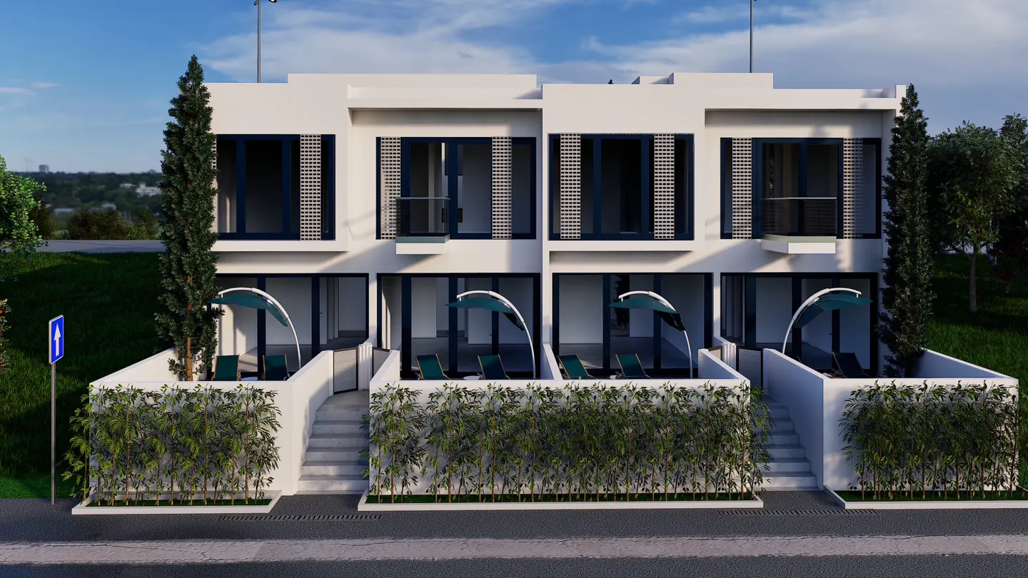 Three modern white townhouses with blue trim, each with a private patio and green lounge chairs. Bamboo lines the patios.