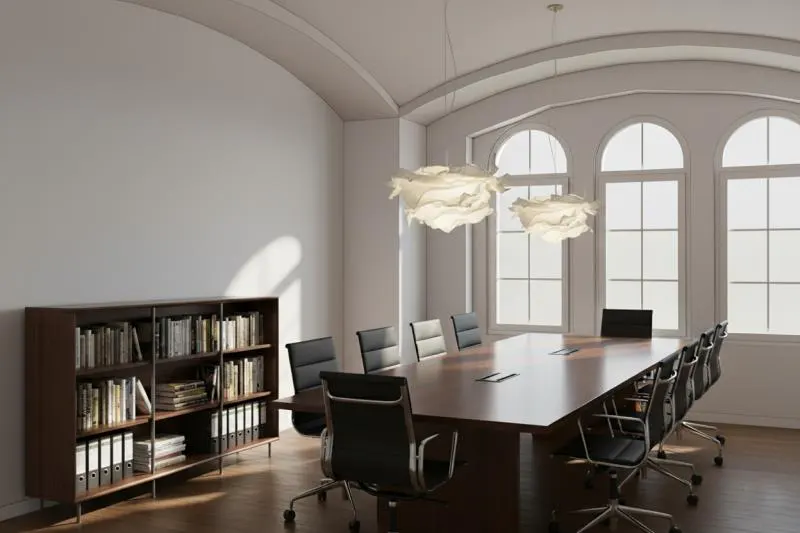 A modern conference room with a long wooden table, black chairs, and a bookshelf. Arched windows provide natural light.
