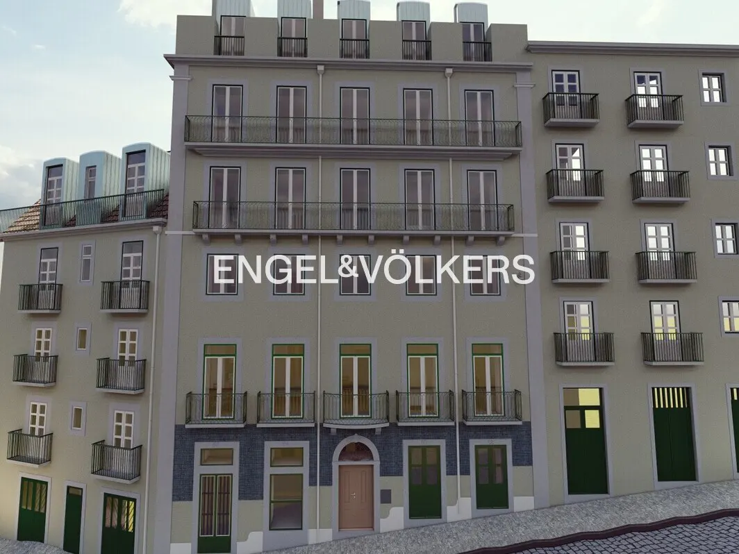A multi-story beige apartment building with balconies and the Engel & Völkers logo on a cobblestone street.