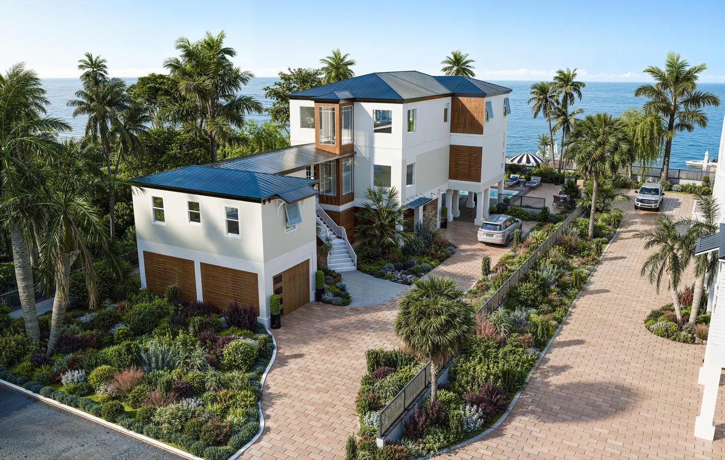 Modern multi-level coastal home with a paved driveway, lush landscaping, and ocean views under a clear blue sky.