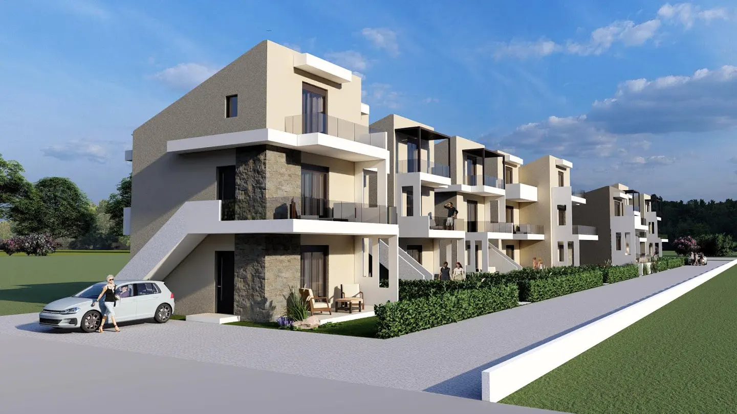 Modern townhouses with balconies, stone accents, and a white car parked in front. Green lawn and blue sky.