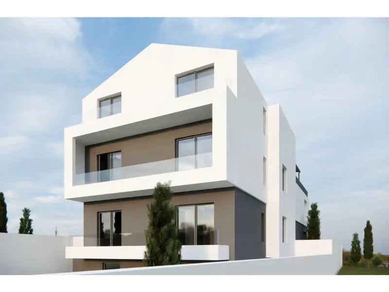 Modern three-story building with white facade, gray accents, and glass balconies under a blue sky.