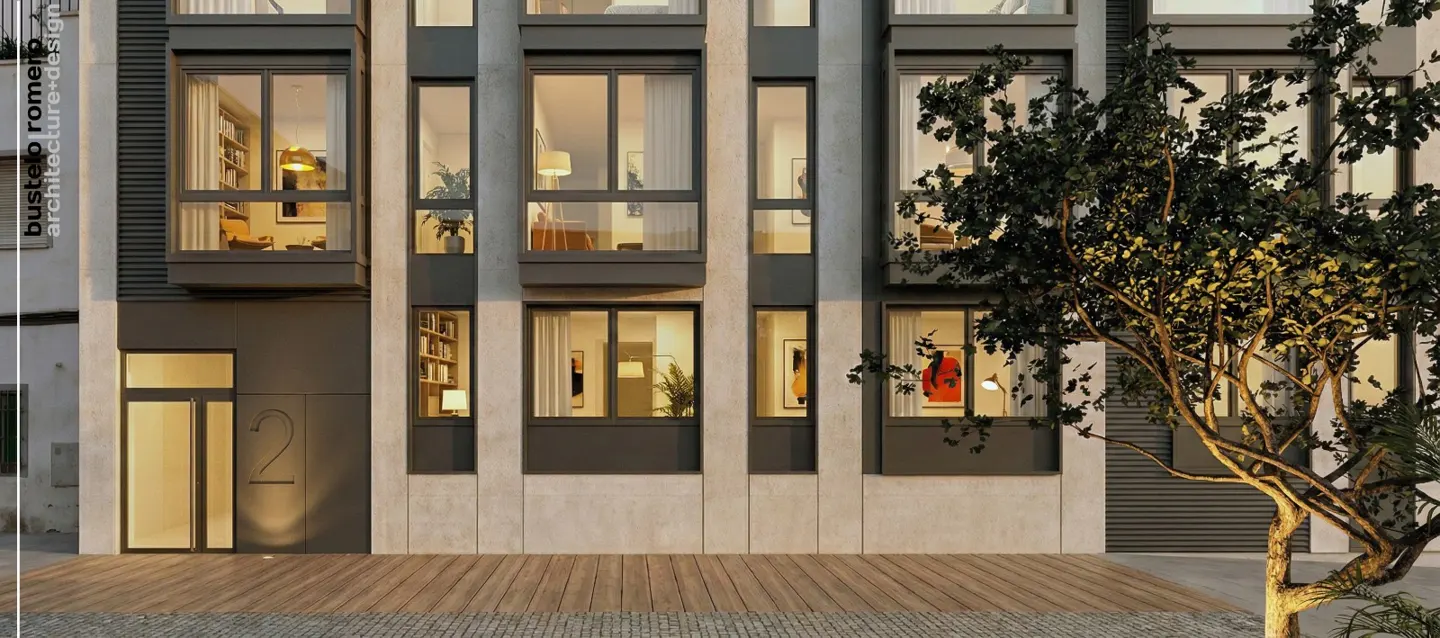 Exterior view of a modern apartment building with large windows, a gray facade, and a wooden walkway. A tree is in the foreground.