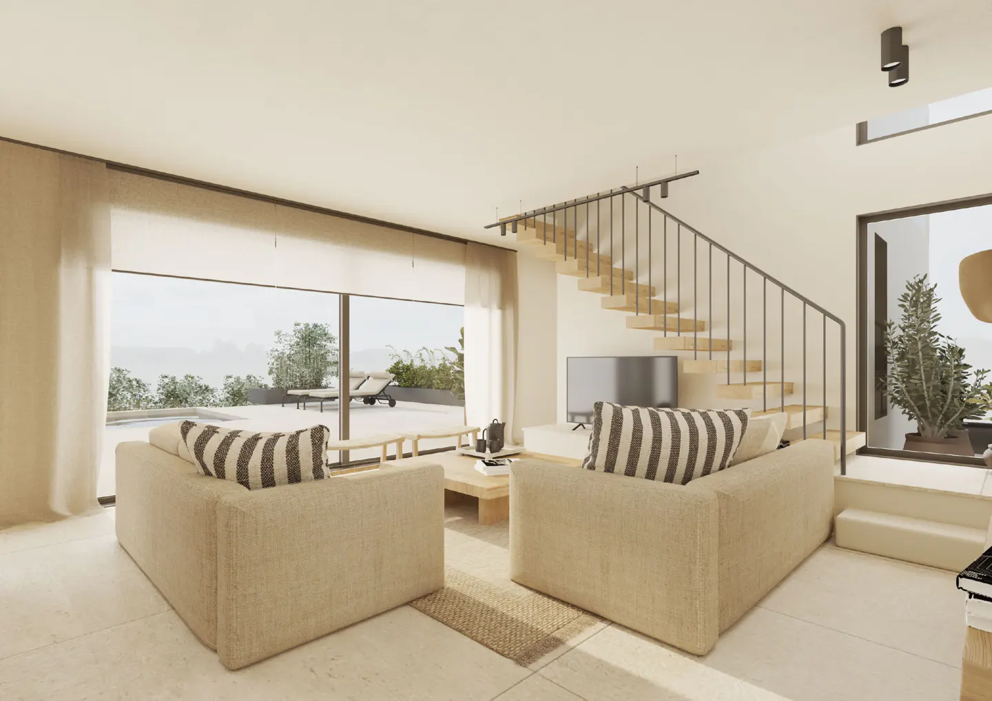 Beige living room with two sofas, striped pillows, a TV, and stairs leading up to the next floor. Outside is a patio with lounge chairs.