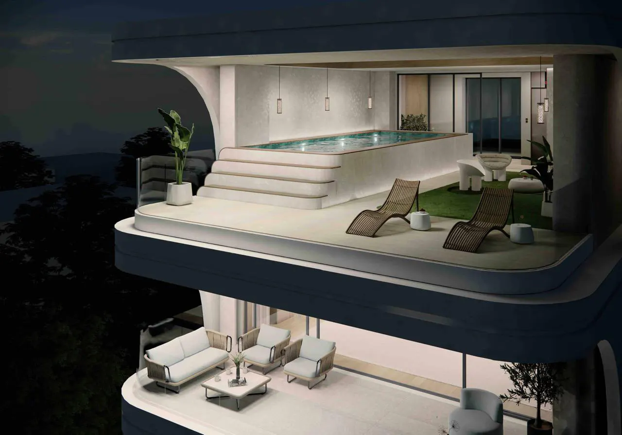 Modern two-story balcony at night featuring an elevated pool, lounge chairs, and a lower-level patio with outdoor seating.