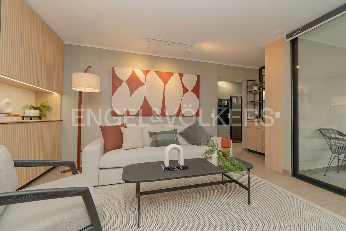 Living room with a white sofa, gray coffee table, and a large abstract painting in red and white. A light wood accent wall is on the left.