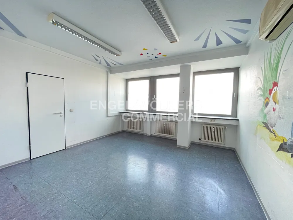Empty room with blue floor, white walls, and three windows. A mural of a rooster and other animals is on one wall.