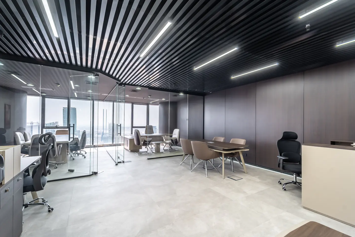 Modern office space with glass-walled conference room, black slatted ceiling, and city view. Neutral tones and clean lines.