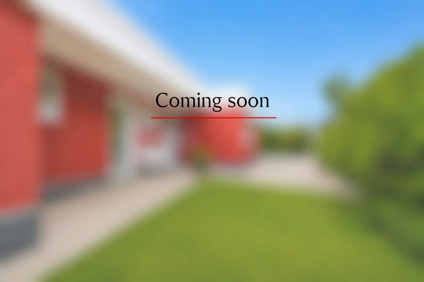 Blurred image of a red house exterior with a green lawn and blue sky, featuring the text "Coming soon" in the center.
