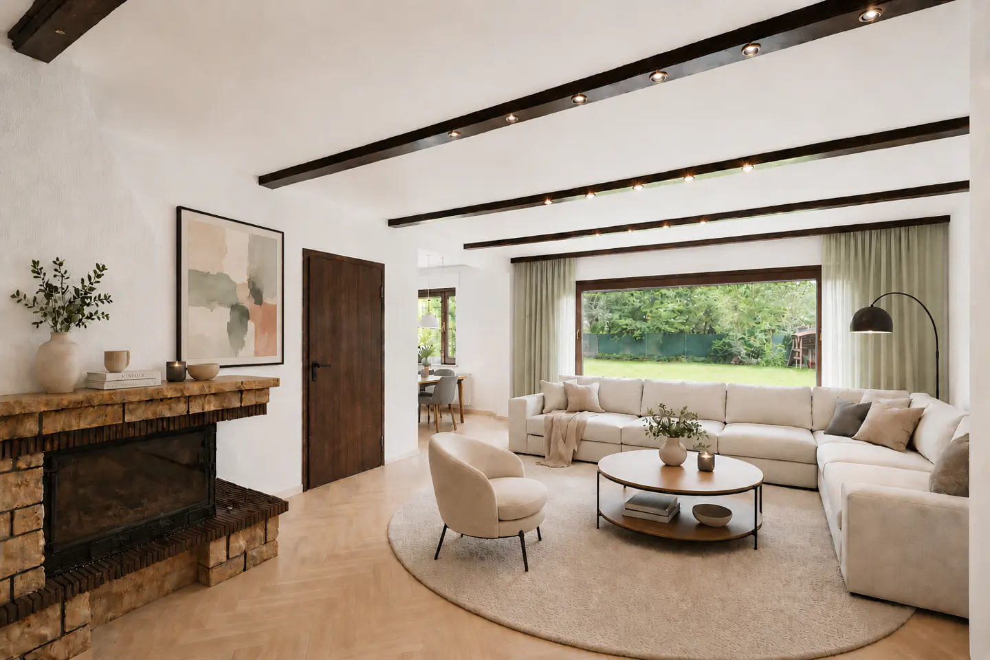 Bright living room with a brick fireplace, beige sofa, round rug, and a large window overlooking a green yard.