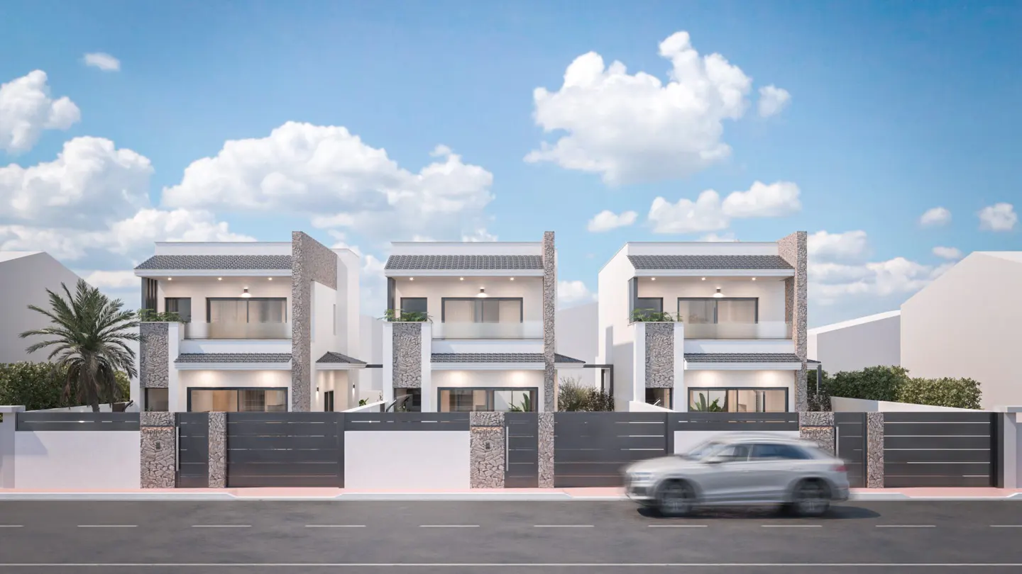 Three modern, two-story white townhouses with gray roofs and stone accents behind a gray fence. A car drives by on the street.