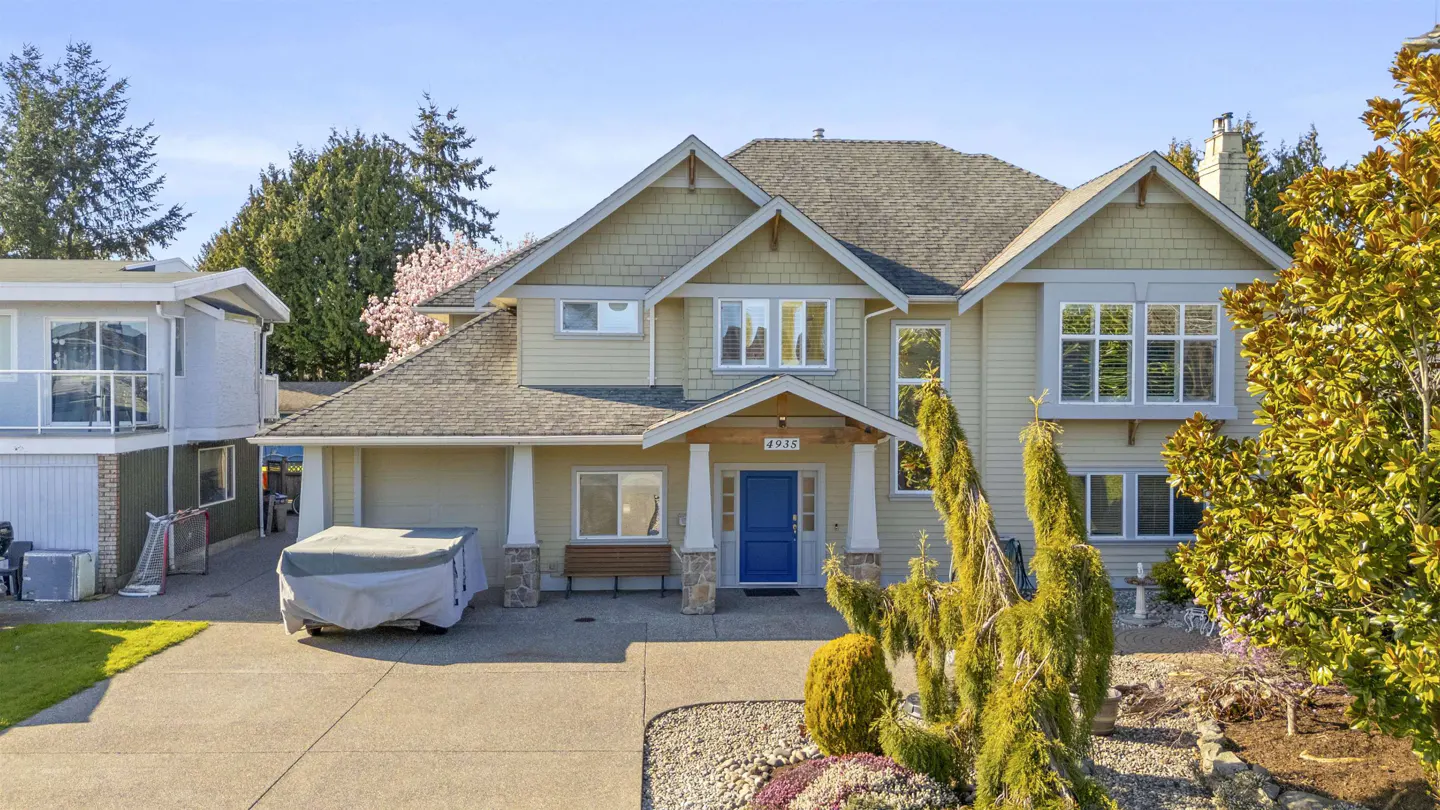 Two-story beige house with a blue front door and a covered car in the driveway.