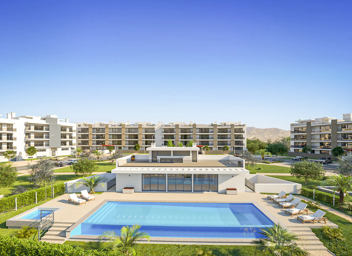 Apartment complex with a pool. White buildings with balconies surround a blue swimming pool and lounge chairs. Clear blue sky.