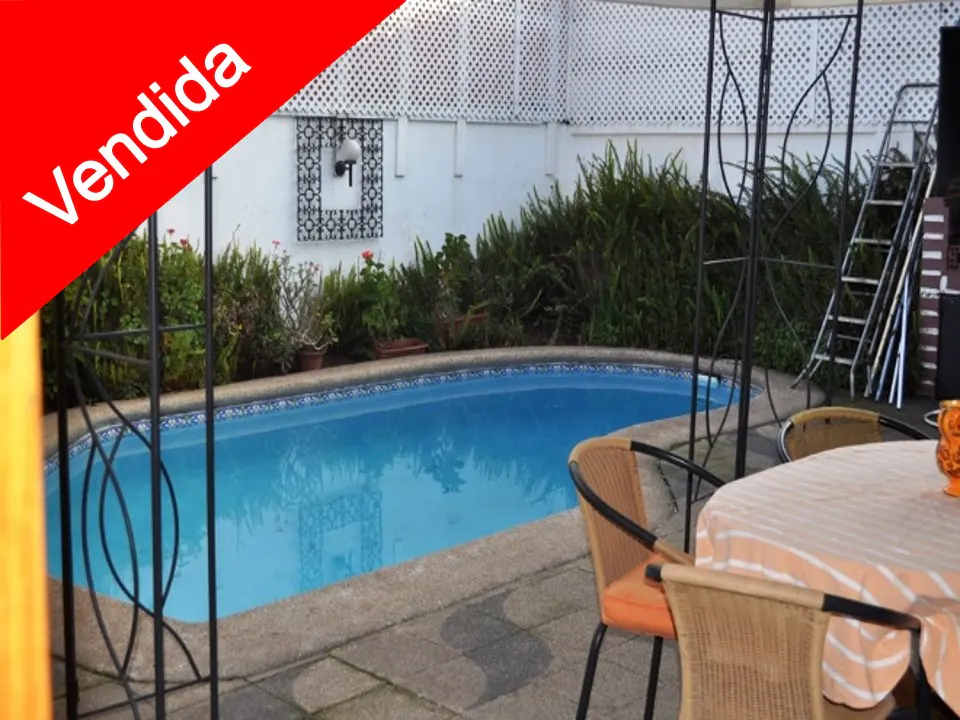 Outdoor patio with a blue tiled pool, table with chairs, and a red "Vendida" banner in the corner.