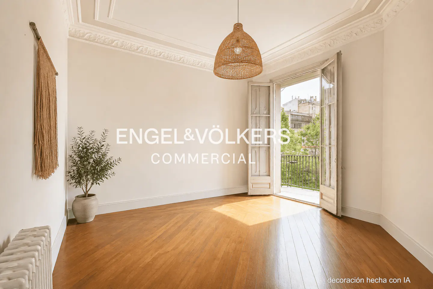 Bright room with wood floors, white walls, and balcony doors open to a city view. A woven pendant light hangs above.