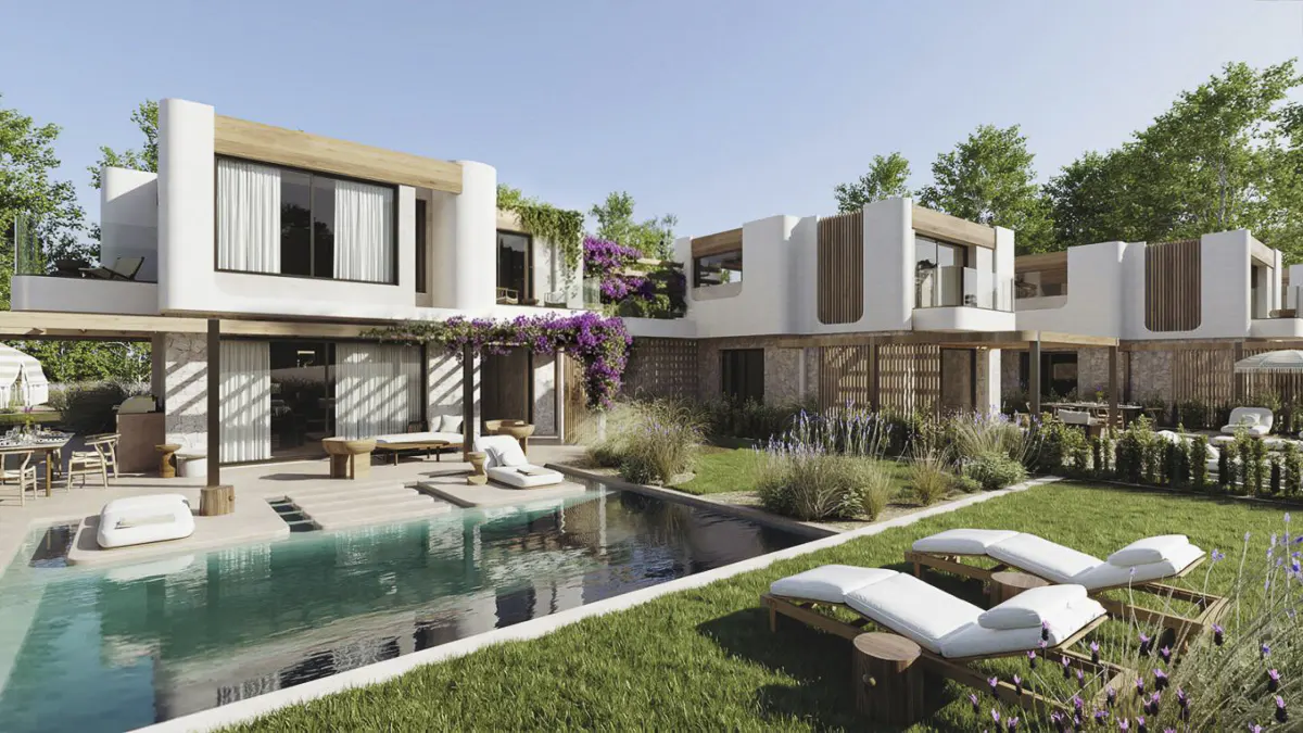 Modern white house with a pool and lounge chairs on the green lawn under a blue sky.