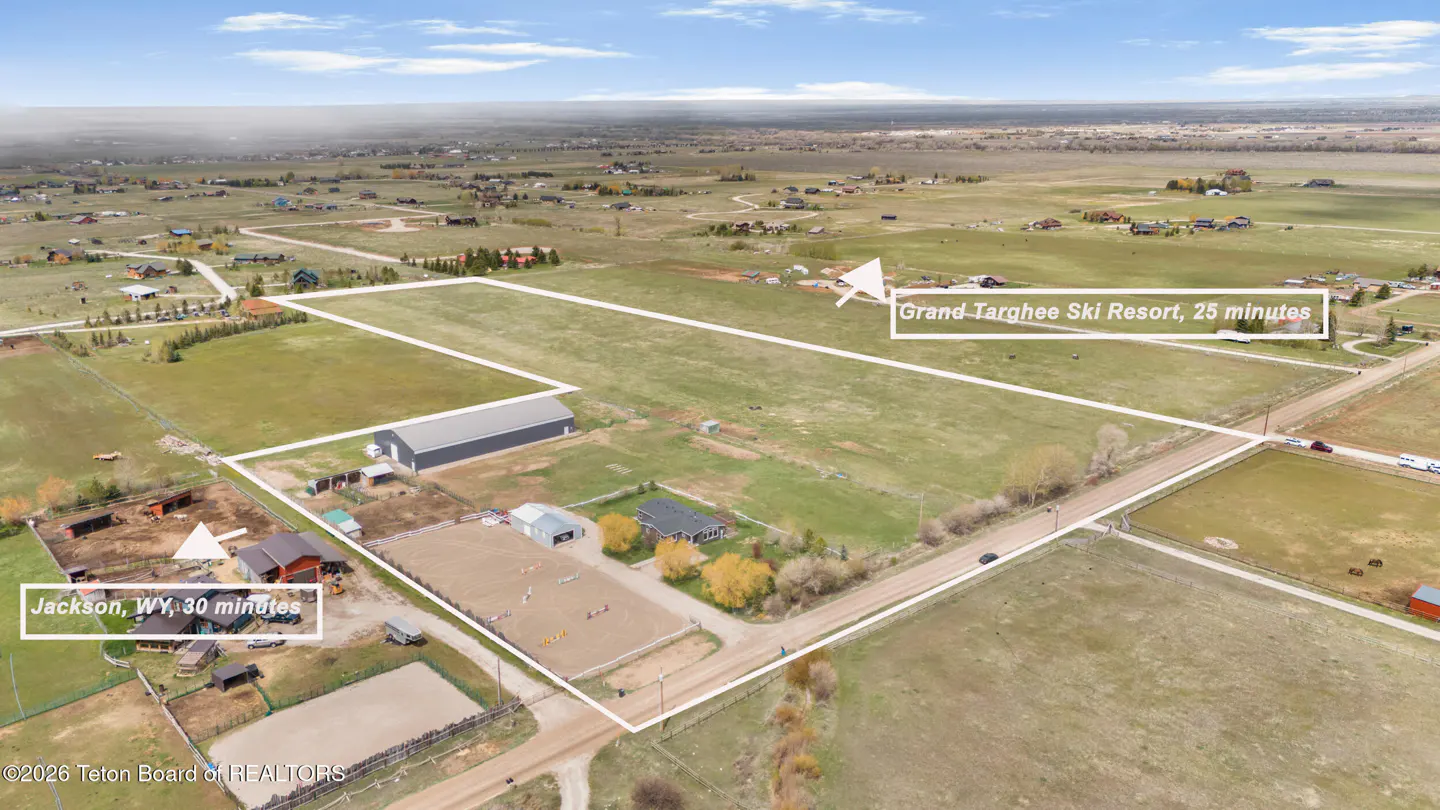 Aerial view of a large rural property with a house, barn, and riding arena, marked with proximity to Jackson and ski resort.
