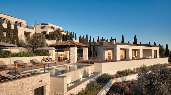 Luxury villa with a stone terrace, infinity pool, and pergola, surrounded by cypress trees under a clear blue sky.