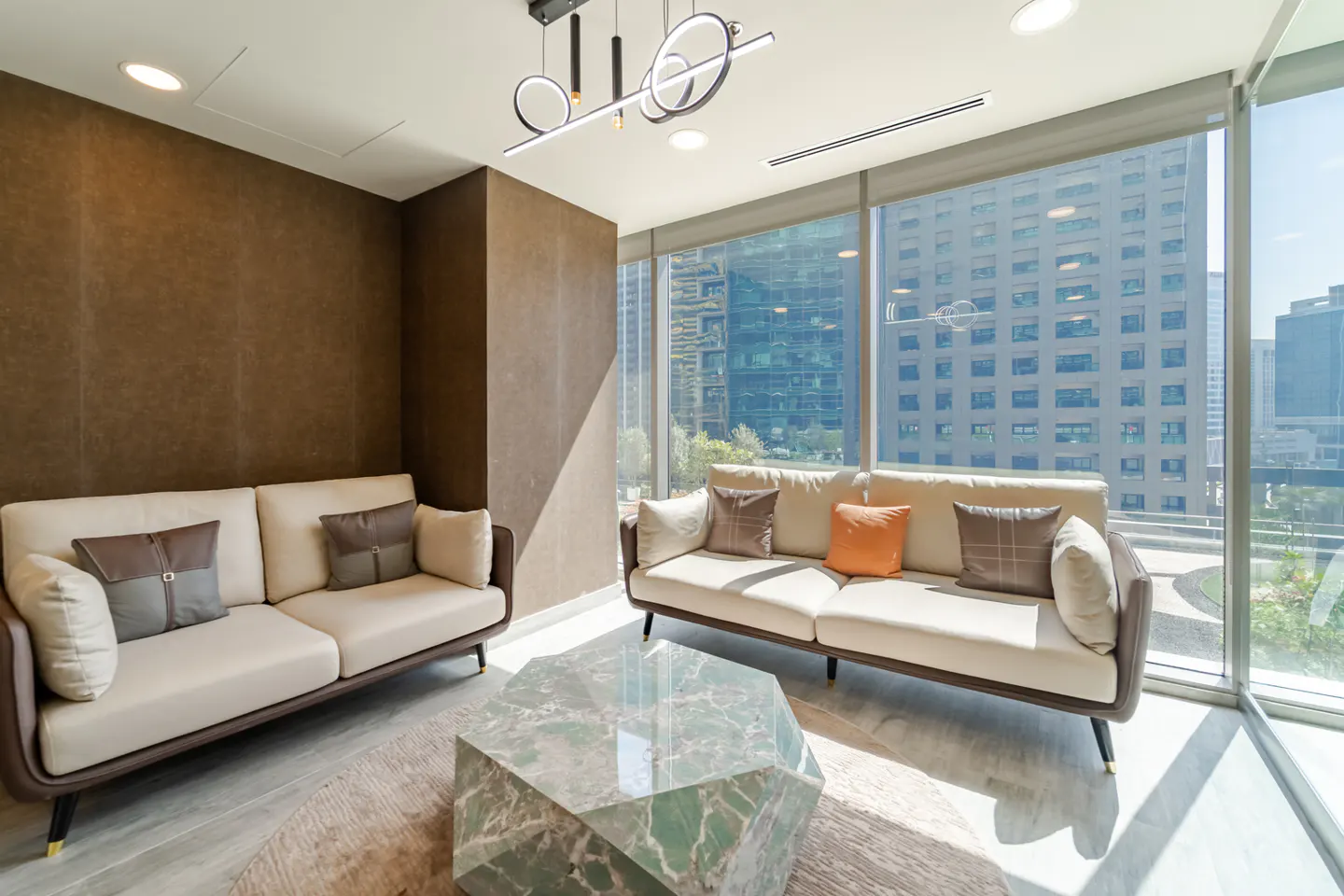 Living room with two sofas, a marble coffee table, and a large window with a city view.