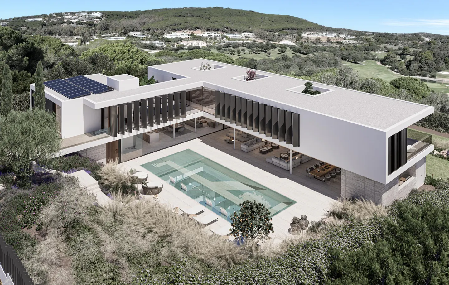 Aerial view of a modern white house with a pool, solar panels, and a flat roof, surrounded by lush greenery.